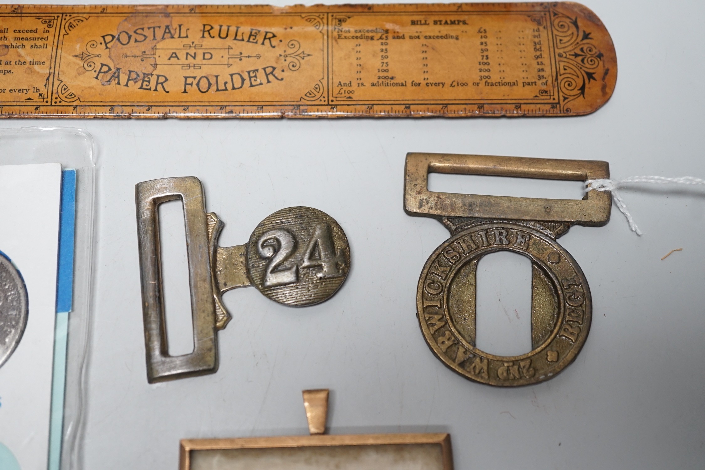 A collection of collectibles: a mother of pearl carves fish, a Mauchlin postal ruler, an enamel box and trays, coinage and various military badges etc